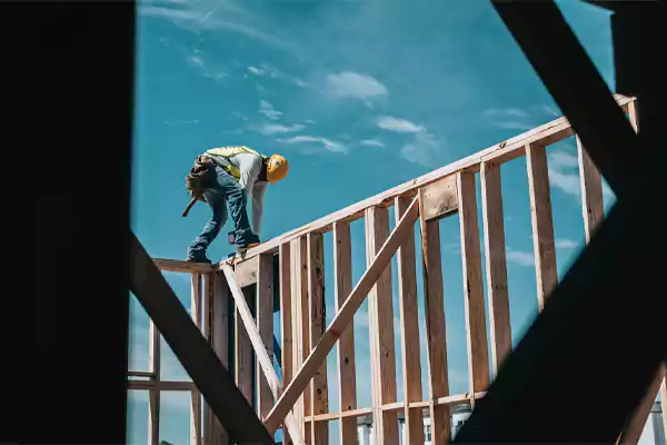 A Construction Worker Building Wood Frames