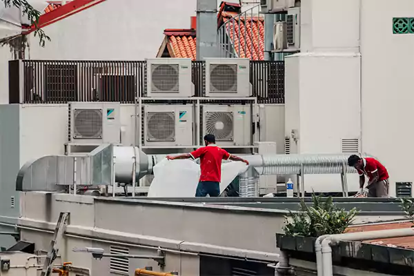 Expert workers repairing HVAC systems on a commercial premises