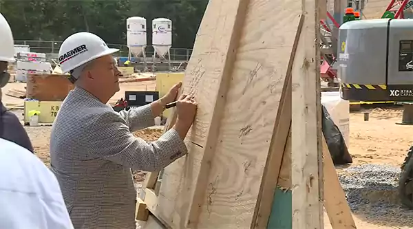 Team members signing over the top beam of the Dellshire Resort marking the topping off ceremony