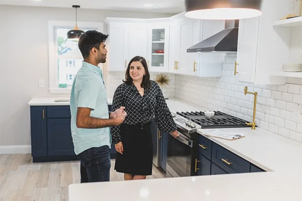 Couple exploring a modern kitchen space during a real estate tour