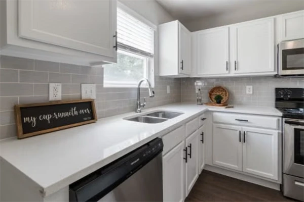 Modern kitchen interior showcasing white cabinets and sleek design with natural light