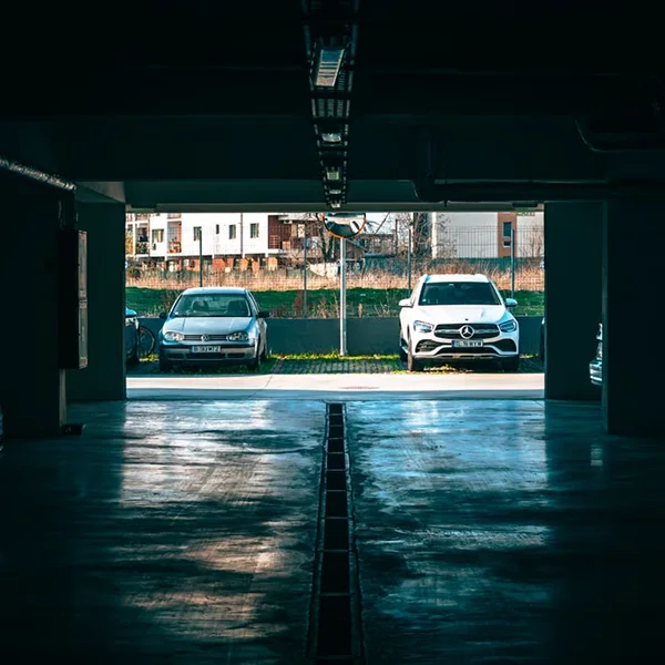 Two parked cars Mercedes and Volkswagen in an urban parking lot during daylight