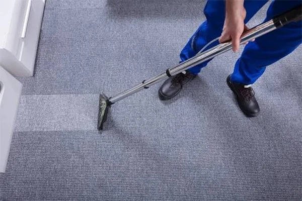 A professional cleaner cleaning carpets at a home with a vacuum cleaner