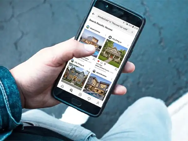 a phone in a person’s hand showing the search result houses